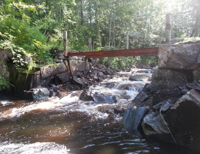Forsande vattendrag med en liten spångbro