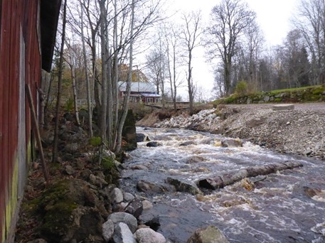 Forsande vatten. En byggnad skymtar till vänster i bilden