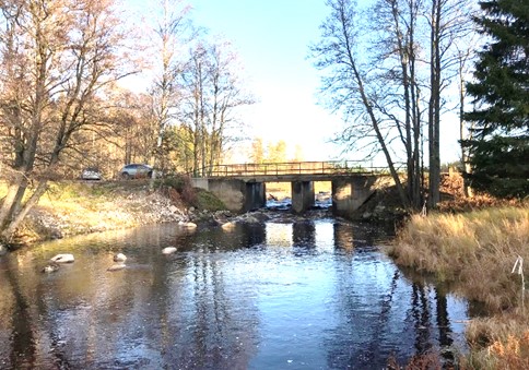 Rinnande vattendrag. En vägbro syns i bakgrunden.