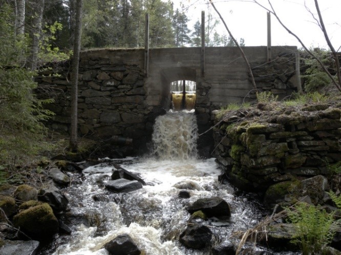 Äldre dammbyggnad med vattenfall