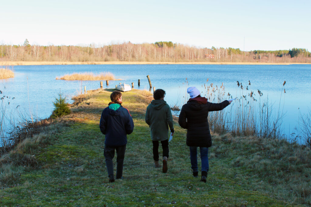 Tre personer vid sjö.