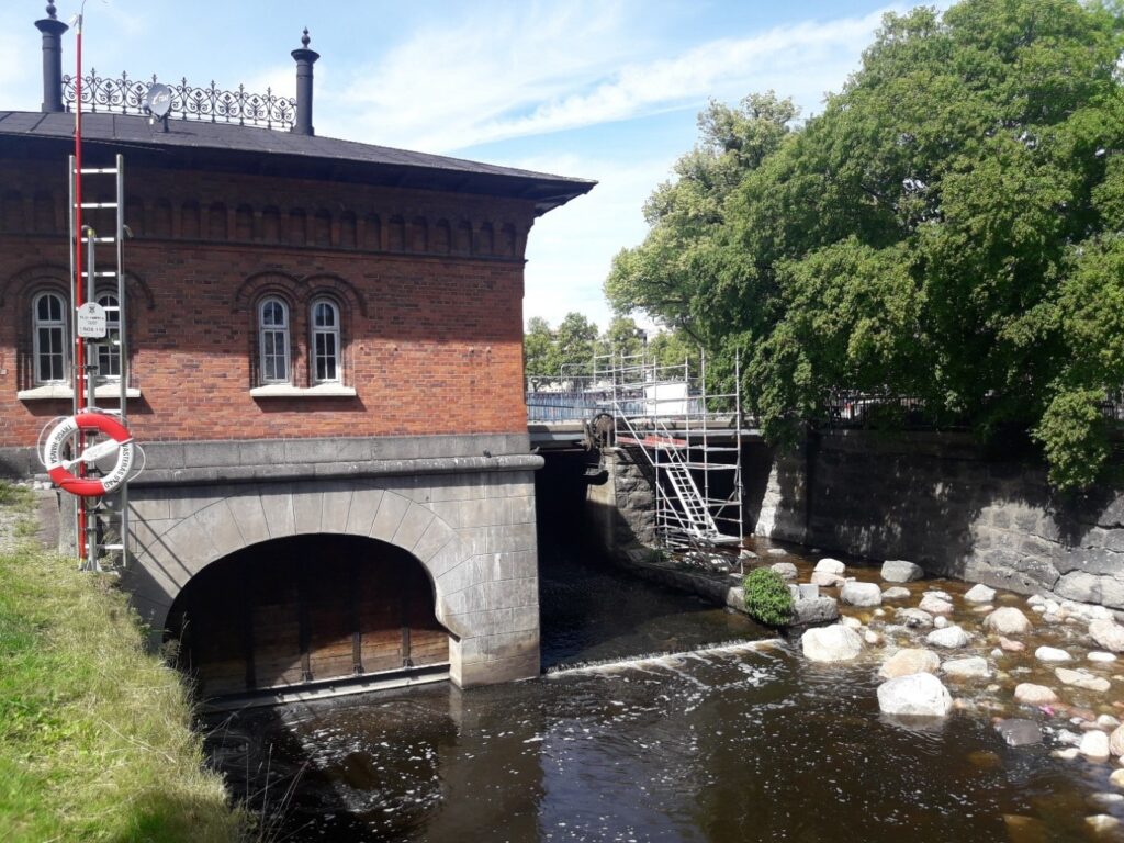 Turbinbron sedd från nedströmssidan. Kraftverket till vänster och fiskvägens utlopp längst till höger i bild