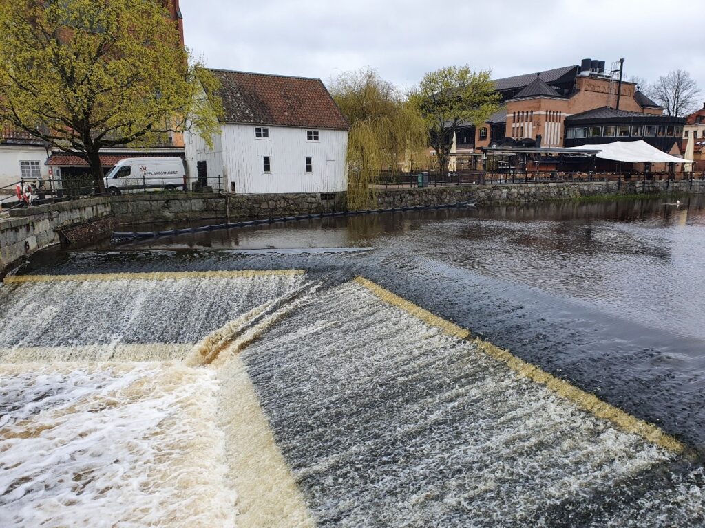 Skibordet/överfallet vid Kvarnfallet i Uppsala. Bakom vattenfallet syns en vit kvarnbyggnad.