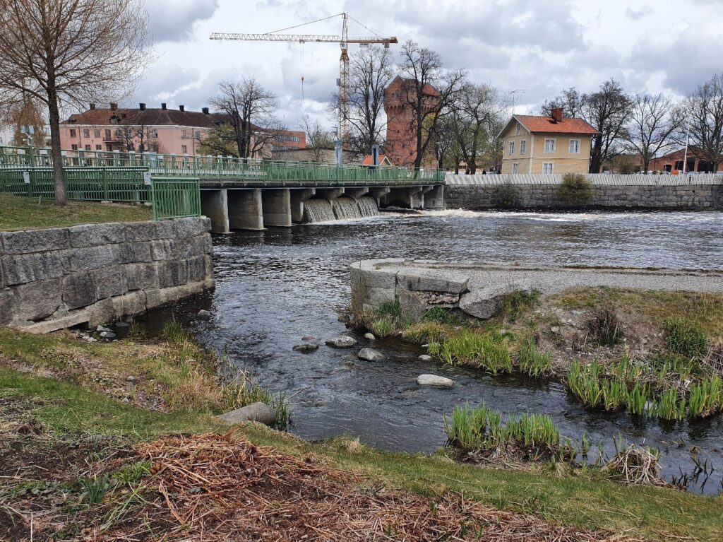 Damm med fallande vatten i stadsmiljö.