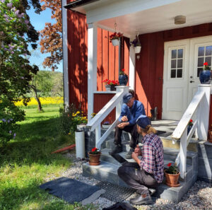 Två män sitter på en veranda och pratar.