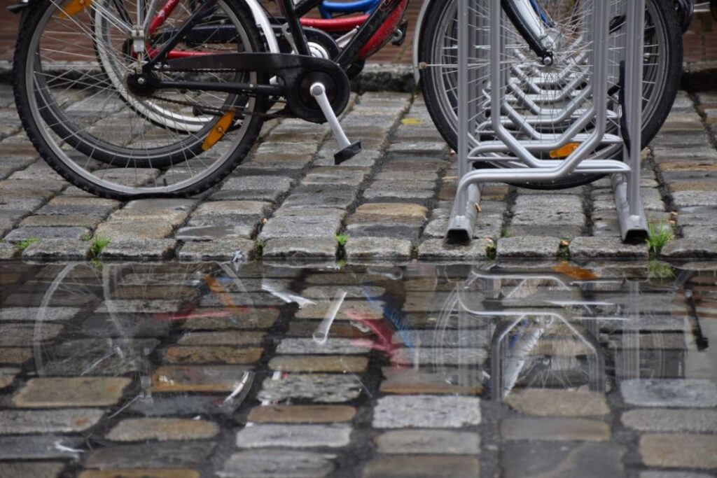 Ett cykelställ och en vattenpöl.