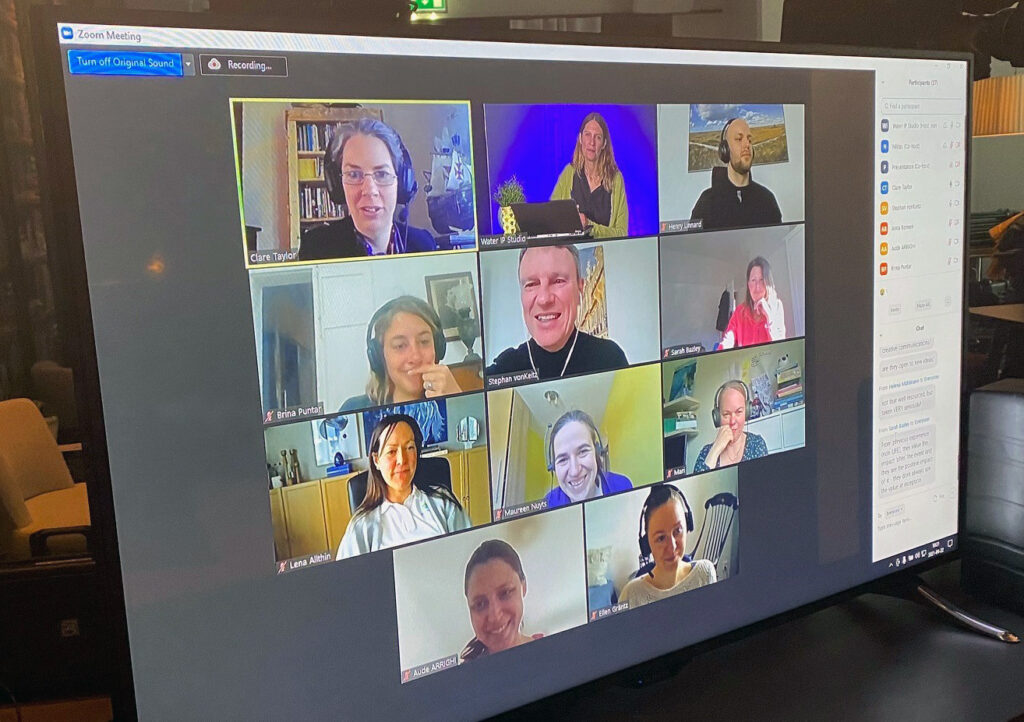 En dataskärm som visar flera män och kvinnor som har ett digitalt möte.