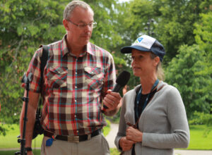 En man intervjuar en kvinna med en mikrofon.