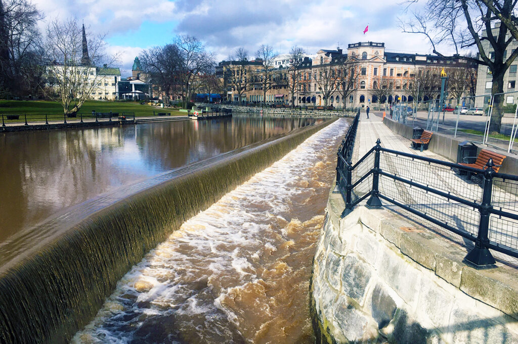 Forsande ström i faunapassagen, till höger i bilden, med stadsmiljö i bakgrunden