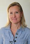 En kvinna med lång ljust hår och blå skjorta.